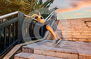 Young blonde woman doing doing push ups over railing banister at sunset