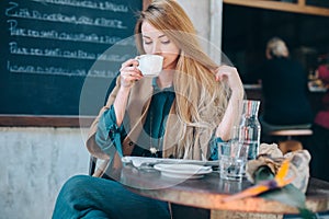 Young blonde woman drinking coffee cup background lifestule