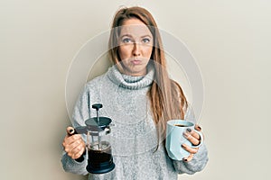 Young blonde woman drinking a cup of italian coffee depressed and worry for distress, crying angry and afraid