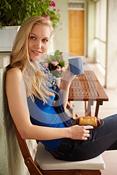 Young blonde woman drinking tea in the terrace