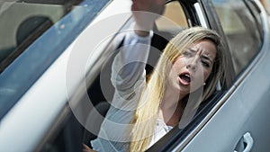 Young blonde woman driving car screaming for traffic problem at street