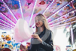 Young blonde woman eats cotton candy floss