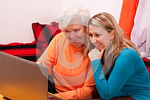 Young blonde woman explains an older an laptop