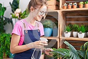 Young blonde woman florist using diffuser working smiling at flower shop