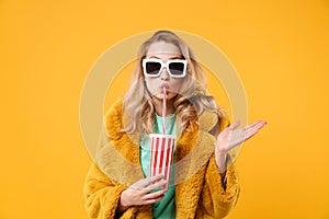 Young blonde woman girl in yellow fur coat, dark sunglasses posing isolated on orange background. People lifestyle