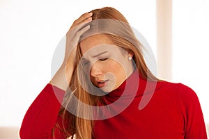 Young blonde woman having serious migrene suffering from horrible head ache feeling horrible pain