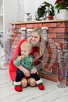 Young blonde woman holds her tiny son on her lap