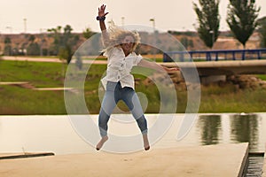 Young blonde woman jumping for joy