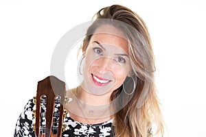 Young blonde woman with long hair posing with wooden acoustic guitar on white wall background
