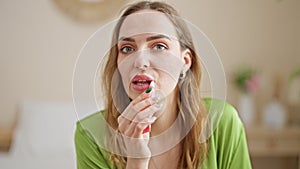 Young blonde woman make up lips smiling at bedroom