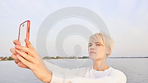 Young blonde woman makes selfy