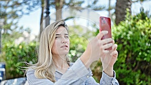 Young blonde woman making selfie by the smartphone at park
