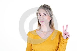 Young blonde woman over isolated white background smiling showing v finger victory sign hand