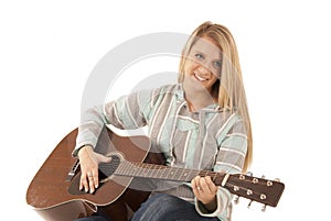 Young blonde woman playing acoustic guitar