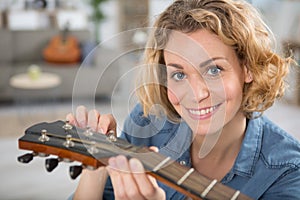 young blonde woman before playing guitar