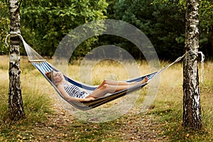 Young blonde woman resting on hammock