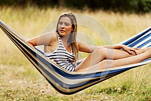 Young blonde woman resting on hammock