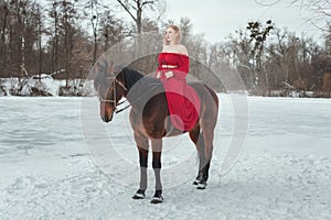 Young blonde woman riding a horse.