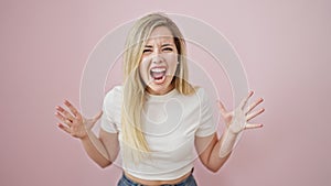 Young blonde woman screaming loudly over isolated pink background