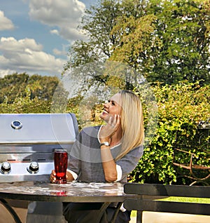 young blonde woman sited at the table having a drink