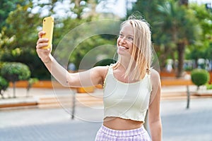 Young blonde woman smiling confident making selfie by the smartphone at park