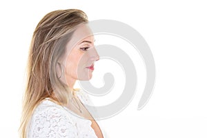 Young blonde woman standing in profile on white background with copy space empty for text side view portrait