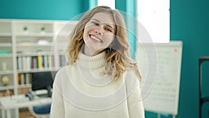 Young blonde woman student smiling confident standing at library university