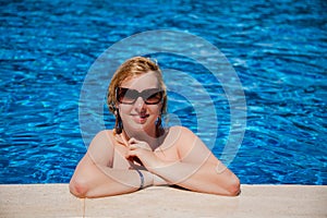 Young blonde woman in swimming pool bathing