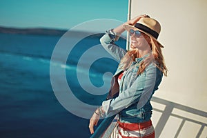 Young blonde woman traveler posing on cruise ship deck
