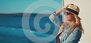 Young blonde woman traveler posing on cruise ship deck banner