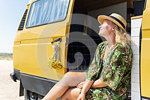 Young blonde woman travelling by campervan at the seaside