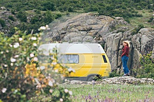 Young blonde woman travelling by campervan though the countryside