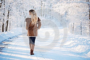 Young blonde woman walking winter park