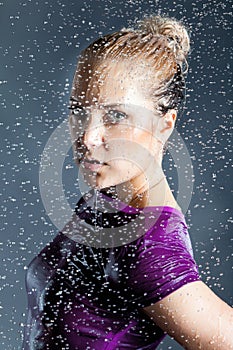 Young blonde woman in water splashes