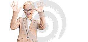 Young blonde woman wearing business clothes and glasses showing and pointing up with fingers number ten while smiling confident