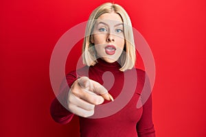 Young blonde woman wearing casual clothes pointing displeased and frustrated to the camera, angry and furious with you