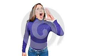 Young blonde woman wearing casual clothes shouting and screaming loud to side with hand on mouth