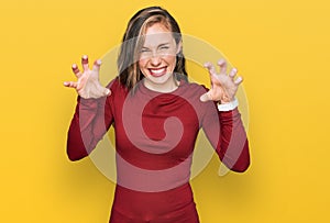 Young blonde woman wearing casual clothes smiling funny doing claw gesture as cat, aggressive and sexy expression