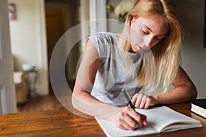 Young blonde woman writting notes photo