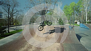 A young bmx rider practicing in the empty skate park