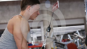 Young bodybuilder man doing the exercise for the triceps at the gym