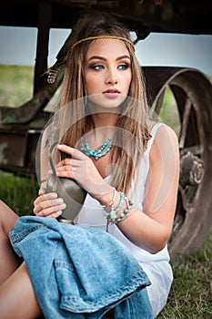 Young boho girl in jacket with blue eyes with pitcher in her hands