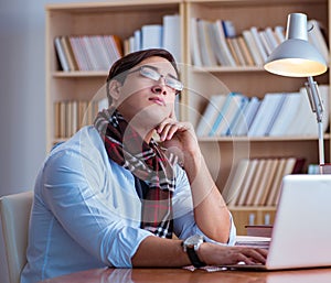 Young book writer writing in library