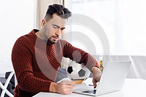 young bookmaker holding credit card near