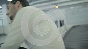 Young bored man sitting at the luggage conveyor in the airport