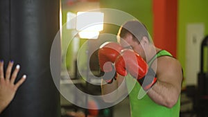 Young boxer man practicing on a punching bag