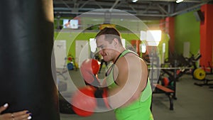 Young boxer man practicing on a punching bag