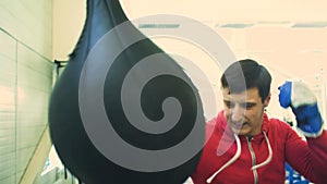 Young boxer man practicing on a punching bag