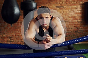 Young boxer in sportive clothes have practice in the gym