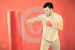 Young boxer training on a punching bag warm filter applied